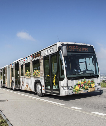 Das Bild zeigt einen Bus mit Werbung auf dem ganzen Bus.